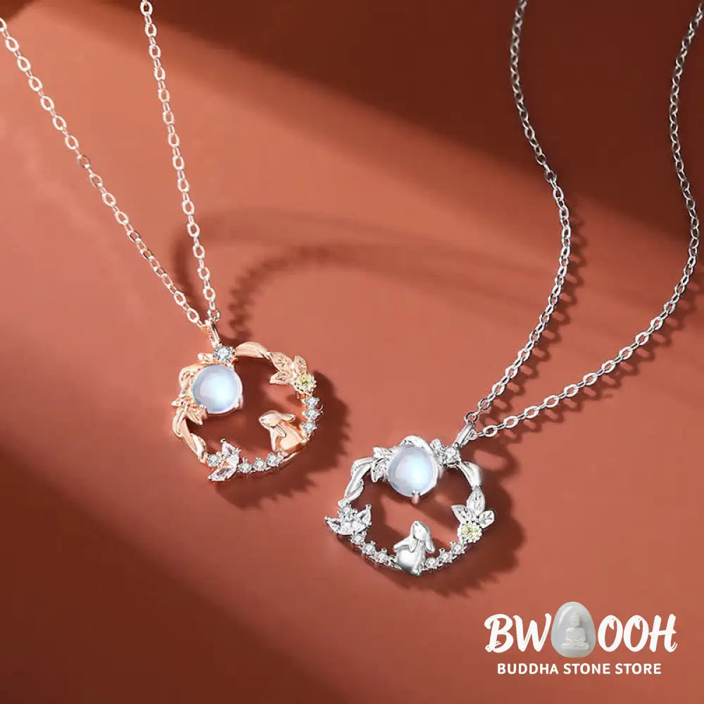 A complete BWOOOH 925 Sterling Silver Year of the Rabbit Moonstone Moon Flower Pattern Necklace, Pendant, Bracelet, and Earrings set on a serene, reflective surface. Each piece features natural moonstone with its ethereal blue adularescence, set in intricate silver moon flower motifs. The pendant prominently displays the rabbit emblem, symbolizing peace, elegance, and good fortune, evoking spiritual balance. - View 4