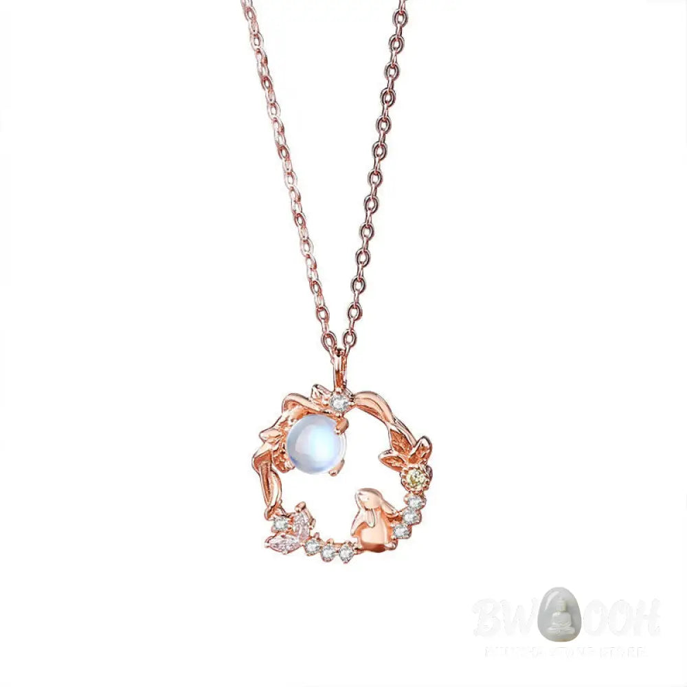A complete BWOOOH 925 Sterling Silver Year of the Rabbit Moonstone Moon Flower Pattern Necklace, Pendant, Bracelet, and Earrings set on a serene, reflective surface. Each piece features natural moonstone with its ethereal blue adularescence, set in intricate silver moon flower motifs. The pendant prominently displays the rabbit emblem, symbolizing peace, elegance, and good fortune, evoking spiritual balance. - View 11