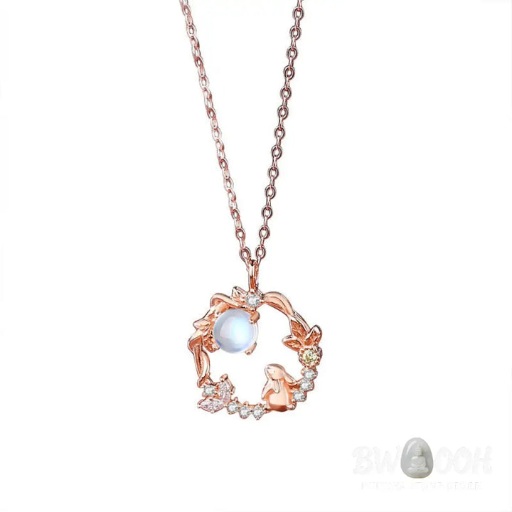 A complete BWOOOH 925 Sterling Silver Year of the Rabbit Moonstone Moon Flower Pattern Necklace, Pendant, Bracelet, and Earrings set on a serene, reflective surface. Each piece features natural moonstone with its ethereal blue adularescence, set in intricate silver moon flower motifs. The pendant prominently displays the rabbit emblem, symbolizing peace, elegance, and good fortune, evoking spiritual balance. - View 11