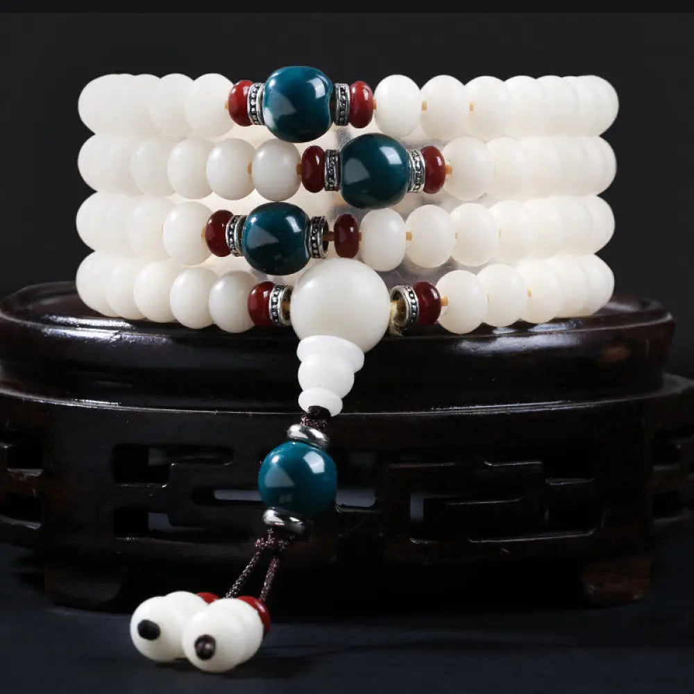A close-up of the BWOOOH Bodhi Seed Lotus Blessing Charm Bracelet, featuring naturally dark-speckled bodhi seed beads alongside a delicate lotus symbol charm, suitable for unisex wear.