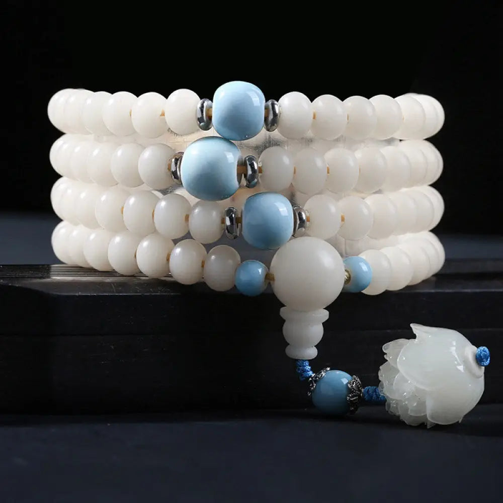 A close-up of the BWOOOH Bodhi Seed Lotus Blessing Charm Bracelet, featuring naturally dark-speckled bodhi seed beads alongside a delicate lotus symbol charm, suitable for unisex wear. - View 11