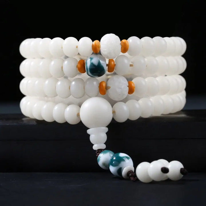 A close-up of the BWOOOH Bodhi Seed Lotus Blessing Charm Bracelet, featuring naturally dark-speckled bodhi seed beads alongside a delicate lotus symbol charm, suitable for unisex wear. - View 14