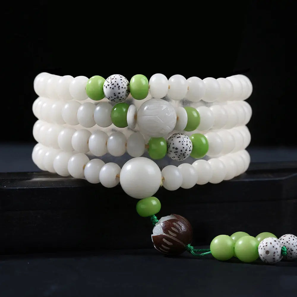 A close-up of the BWOOOH Bodhi Seed Lotus Blessing Charm Bracelet, featuring naturally dark-speckled bodhi seed beads alongside a delicate lotus symbol charm, suitable for unisex wear. - View 16