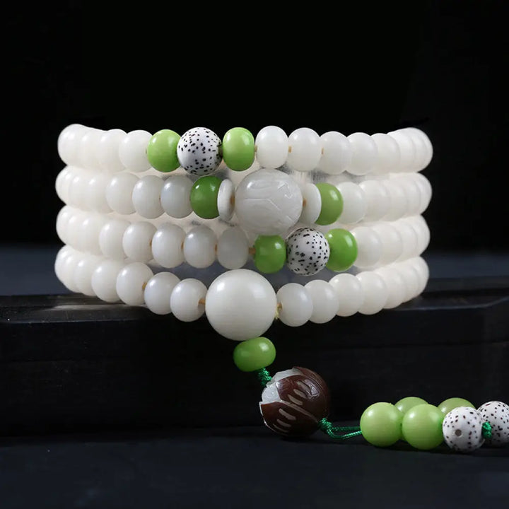 A close-up of the BWOOOH Bodhi Seed Lotus Blessing Charm Bracelet, featuring naturally dark-speckled bodhi seed beads alongside a delicate lotus symbol charm, suitable for unisex wear. - View 16