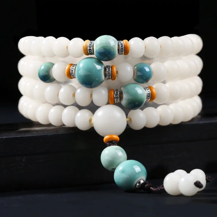 A close-up of the BWOOOH Bodhi Seed Lotus Blessing Charm Bracelet, featuring naturally dark-speckled bodhi seed beads alongside a delicate lotus symbol charm, suitable for unisex wear. - View 9