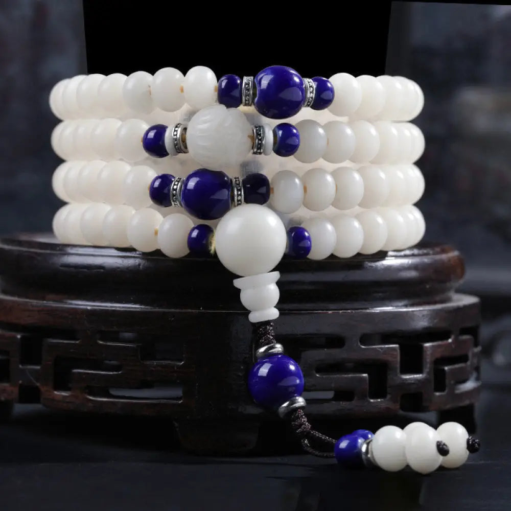 A close-up of the BWOOOH Bodhi Seed Lotus Blessing Charm Bracelet, featuring naturally dark-speckled bodhi seed beads alongside a delicate lotus symbol charm, suitable for unisex wear. - View 5