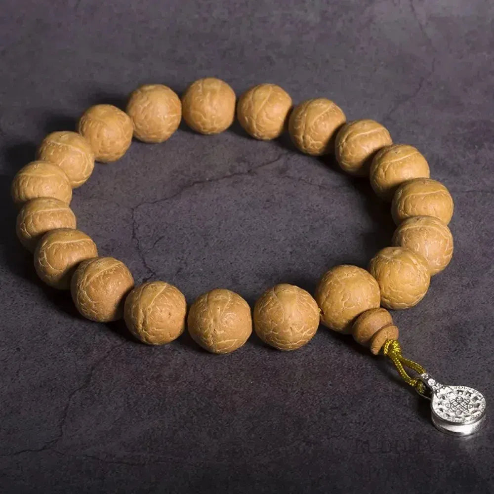 Close-up of BWOOOH Bodhi Seed Wrist Mala featuring dark-speckled 13mm/15mm bodhi seeds on premium elastic string, with a delicate tassel, worn as a meditation accessory or carried as a pocket mala. Unisex. - View 4