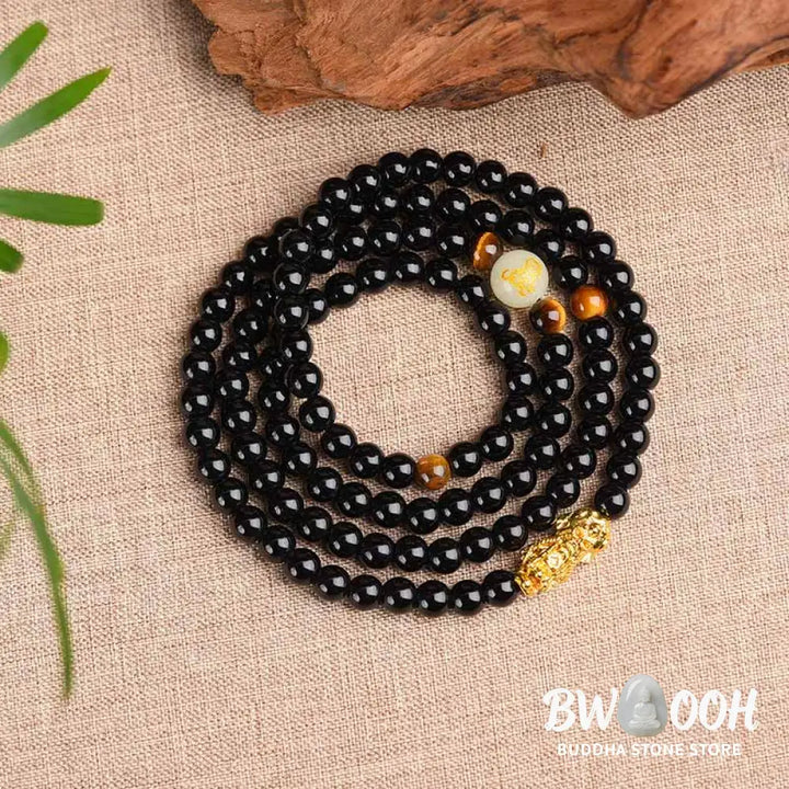 A close-up of the BWOOOH Unisex Chinese Zodiac Obsidian PiXiu Protection Mala Bracelet featuring polished black 6mm or 8mm obsidian beads and a detailed PiXiu charm, designed for spiritual grounding and attracting prosperity. - View 3