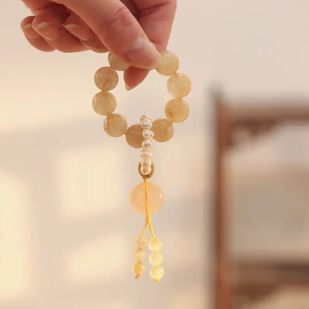 BWOOOH Citrine Peace Buckle Wrist Mala featuring polished 12mm citrine beads, a serene peace buckle symbol, delicate pearl and sakura agate accents, strung on premium material for deep mindfulness and attracting prosperity.