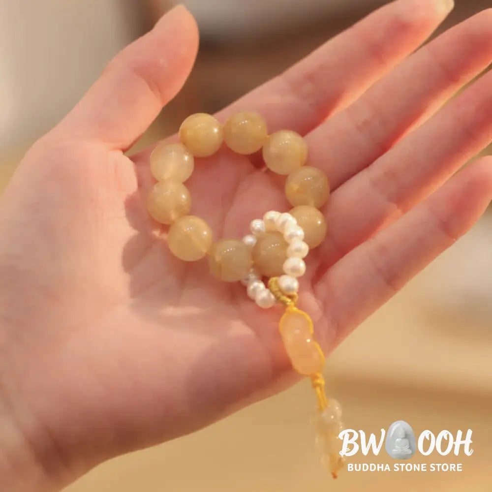 BWOOOH Citrine Peace Buckle Wrist Mala featuring polished 12mm citrine beads, a serene peace buckle symbol, delicate pearl and sakura agate accents, strung on premium material for deep mindfulness and attracting prosperity. - View 3