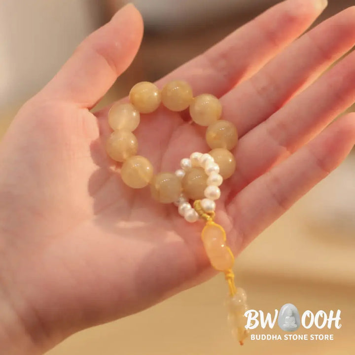 BWOOOH Citrine Peace Buckle Wrist Mala featuring polished 12mm citrine beads, a serene peace buckle symbol, delicate pearl and sakura agate accents, strung on premium material for deep mindfulness and attracting prosperity. - View 3