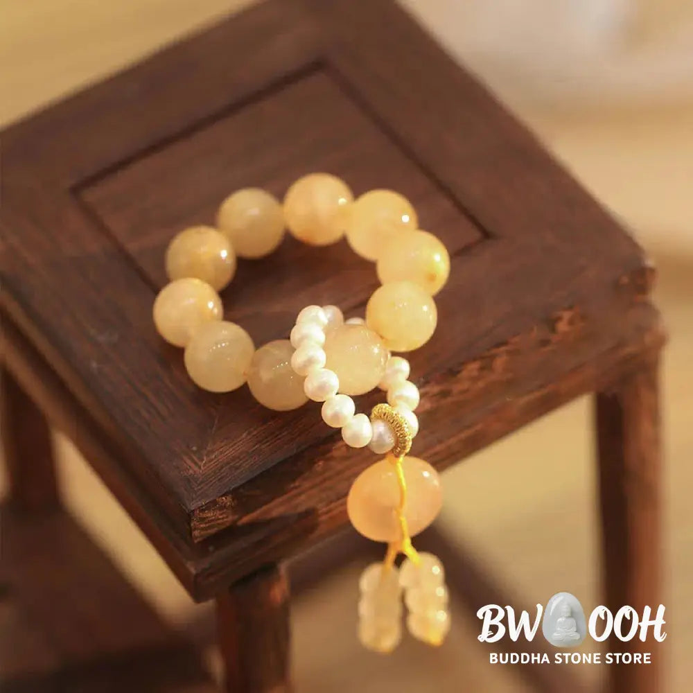 BWOOOH Citrine Peace Buckle Wrist Mala featuring polished 12mm citrine beads, a serene peace buckle symbol, delicate pearl and sakura agate accents, strung on premium material for deep mindfulness and attracting prosperity. - View 2