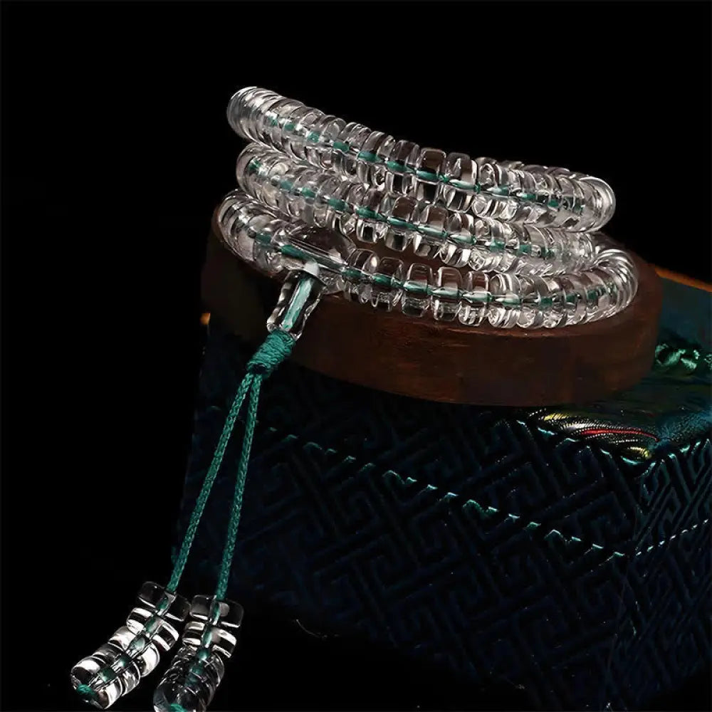 A BWOOOH Liuli 108 Flat Beads Spiral Rope Wisdom Mala, featuring translucent, multi-colored Liuli glass beads crafted with incense ash. The mala is shown wrapped several times around a wrist, ready for meditation and spiritual focus. - View 5