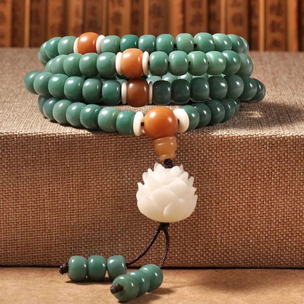 BWOOOH Lotus Cyan Bodhi Seed Success Bracelet showcasing 108 dark-speckled Bodhi seeds and an elegant Lotus symbol. Handcrafted unisex spiritual mala for wisdom, peace, and resilience.