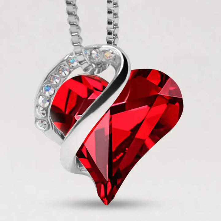 A BWOOOH Love Heart Birthstone Necklace pendant featuring a vibrant, wild-heart-shaped premium crystal, elegantly embraced by a silver-tone ribbon forming an infinity symbol, symbolizing triumph of love and eternal spiritual connection.