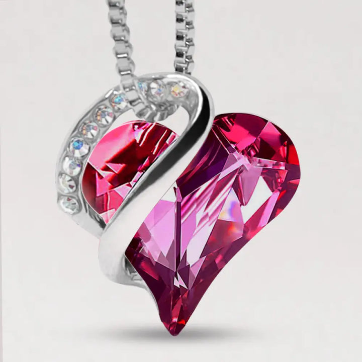 A BWOOOH Love Heart Birthstone Necklace pendant featuring a vibrant, wild-heart-shaped premium crystal, elegantly embraced by a silver-tone ribbon forming an infinity symbol, symbolizing triumph of love and eternal spiritual connection. - View 8
