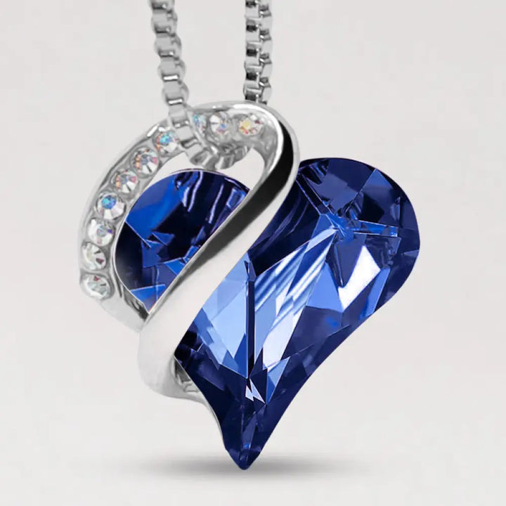 A BWOOOH Love Heart Birthstone Necklace pendant featuring a vibrant, wild-heart-shaped premium crystal, elegantly embraced by a silver-tone ribbon forming an infinity symbol, symbolizing triumph of love and eternal spiritual connection. - View 12