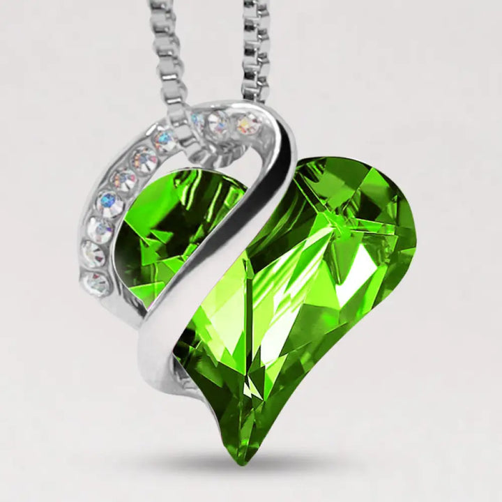 A BWOOOH Love Heart Birthstone Necklace pendant featuring a vibrant, wild-heart-shaped premium crystal, elegantly embraced by a silver-tone ribbon forming an infinity symbol, symbolizing triumph of love and eternal spiritual connection. - View 26