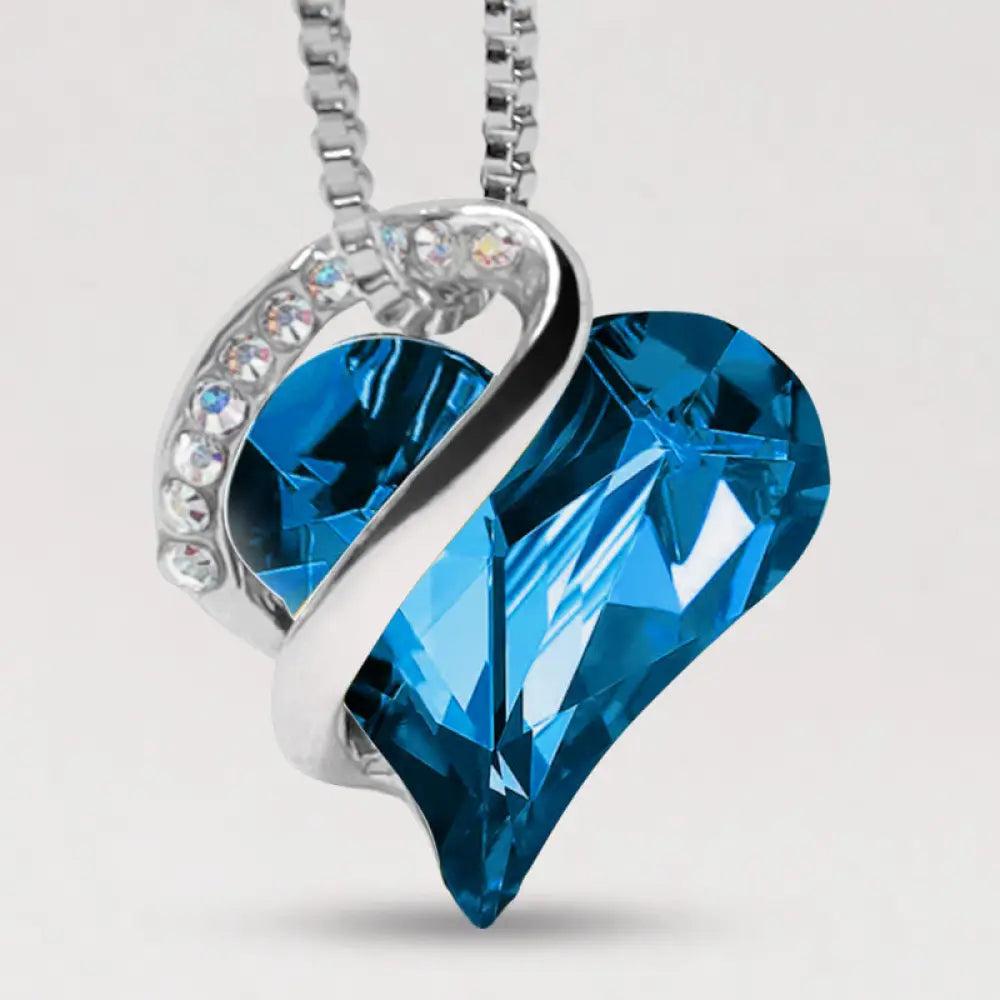 A BWOOOH Love Heart Birthstone Necklace pendant featuring a vibrant, wild-heart-shaped premium crystal, elegantly embraced by a silver-tone ribbon forming an infinity symbol, symbolizing triumph of love and eternal spiritual connection. - View 29
