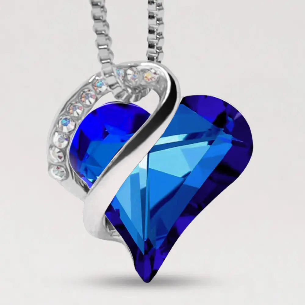 A BWOOOH Love Heart Birthstone Necklace pendant featuring a vibrant, wild-heart-shaped premium crystal, elegantly embraced by a silver-tone ribbon forming an infinity symbol, symbolizing triumph of love and eternal spiritual connection. - View 32