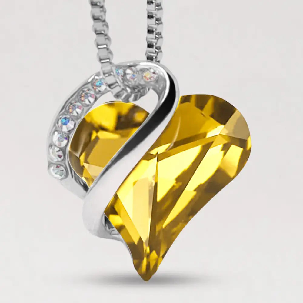 A BWOOOH Love Heart Birthstone Necklace pendant featuring a vibrant, wild-heart-shaped premium crystal, elegantly embraced by a silver-tone ribbon forming an infinity symbol, symbolizing triumph of love and eternal spiritual connection. - View 38