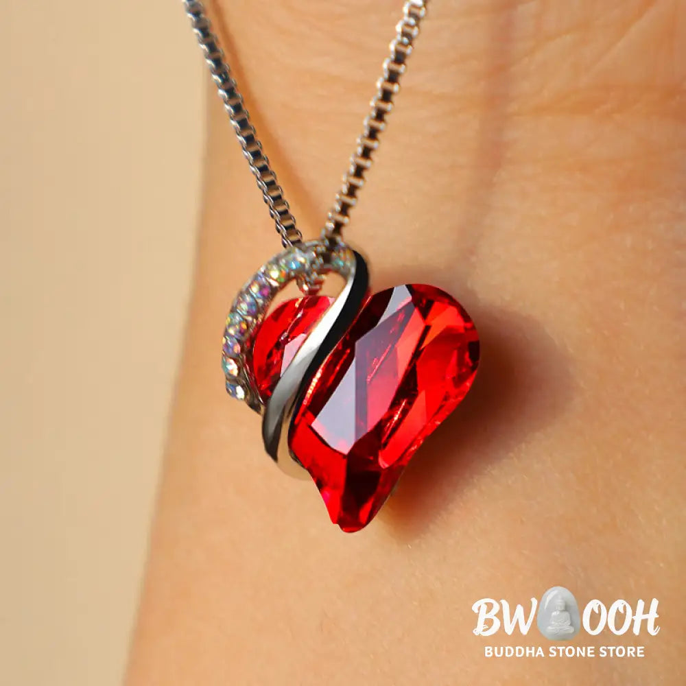 A BWOOOH Love Heart Birthstone Necklace pendant featuring a vibrant, wild-heart-shaped premium crystal, elegantly embraced by a silver-tone ribbon forming an infinity symbol, symbolizing triumph of love and eternal spiritual connection. - View 3