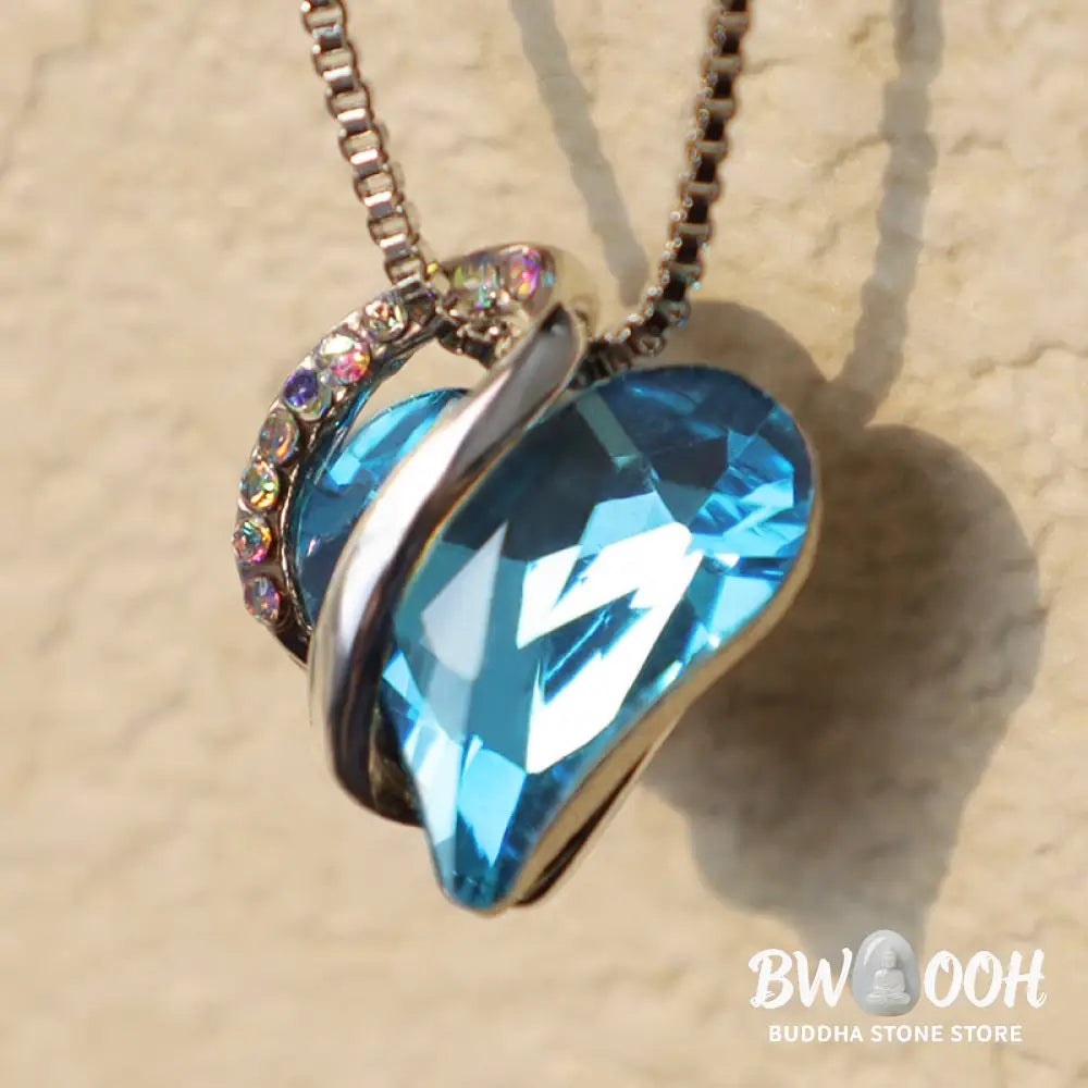 A BWOOOH Love Heart Birthstone Necklace pendant featuring a vibrant, wild-heart-shaped premium crystal, elegantly embraced by a silver-tone ribbon forming an infinity symbol, symbolizing triumph of love and eternal spiritual connection. - View 44