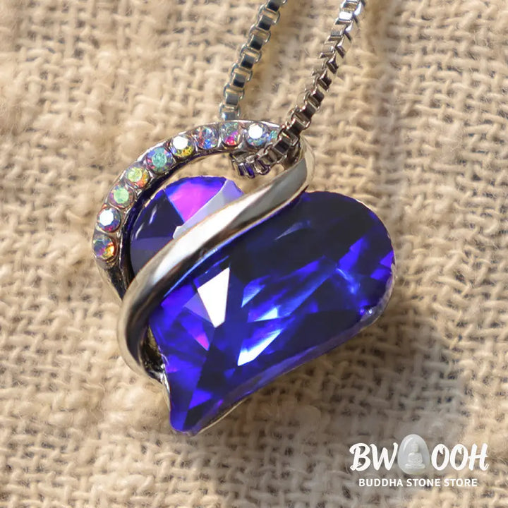 A BWOOOH Love Heart Birthstone Necklace pendant featuring a vibrant, wild-heart-shaped premium crystal, elegantly embraced by a silver-tone ribbon forming an infinity symbol, symbolizing triumph of love and eternal spiritual connection. - View 33