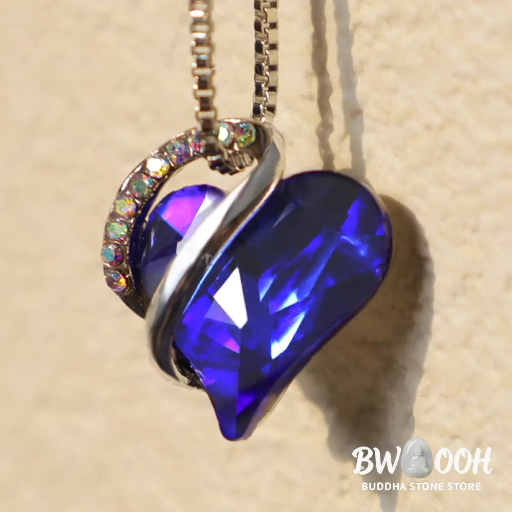 A BWOOOH Love Heart Birthstone Necklace pendant featuring a vibrant, wild-heart-shaped premium crystal, elegantly embraced by a silver-tone ribbon forming an infinity symbol, symbolizing triumph of love and eternal spiritual connection. - View 34