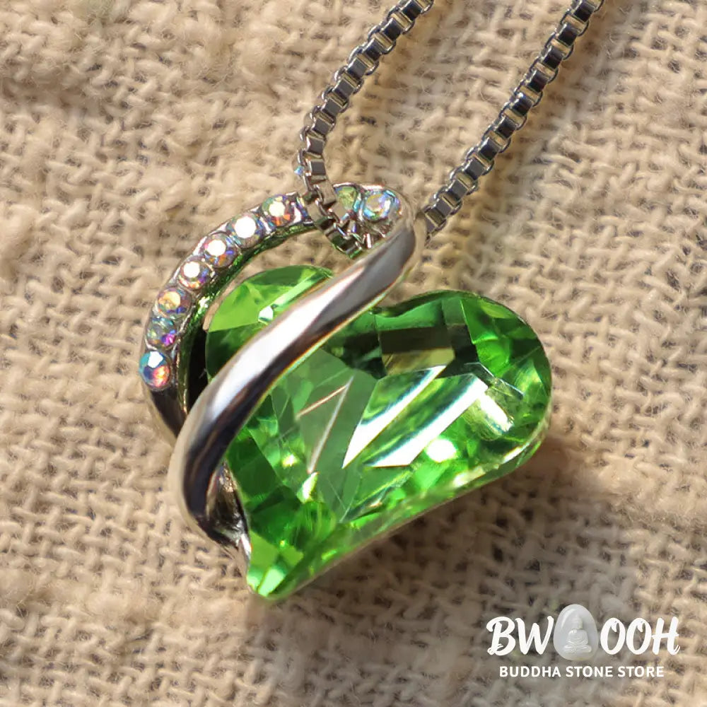 A BWOOOH Love Heart Birthstone Necklace pendant featuring a vibrant, wild-heart-shaped premium crystal, elegantly embraced by a silver-tone ribbon forming an infinity symbol, symbolizing triumph of love and eternal spiritual connection. - View 27