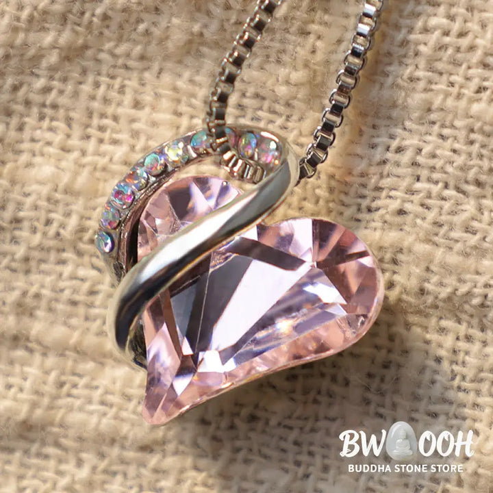 A BWOOOH Love Heart Birthstone Necklace pendant featuring a vibrant, wild-heart-shaped premium crystal, elegantly embraced by a silver-tone ribbon forming an infinity symbol, symbolizing triumph of love and eternal spiritual connection. - View 36