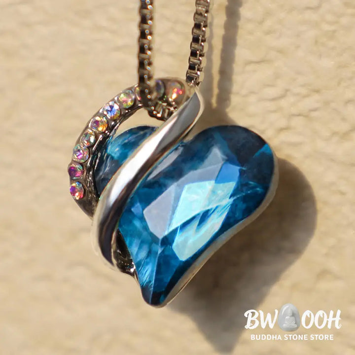 A BWOOOH Love Heart Birthstone Necklace pendant featuring a vibrant, wild-heart-shaped premium crystal, elegantly embraced by a silver-tone ribbon forming an infinity symbol, symbolizing triumph of love and eternal spiritual connection. - View 31