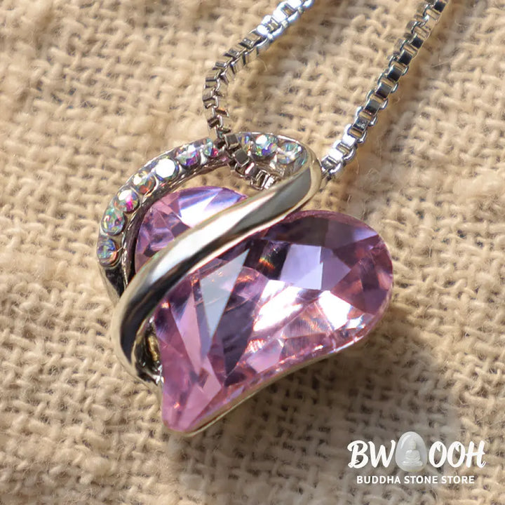 A BWOOOH Love Heart Birthstone Necklace pendant featuring a vibrant, wild-heart-shaped premium crystal, elegantly embraced by a silver-tone ribbon forming an infinity symbol, symbolizing triumph of love and eternal spiritual connection. - View 24