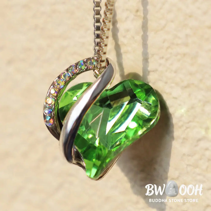 A BWOOOH Love Heart Birthstone Necklace pendant featuring a vibrant, wild-heart-shaped premium crystal, elegantly embraced by a silver-tone ribbon forming an infinity symbol, symbolizing triumph of love and eternal spiritual connection. - View 28