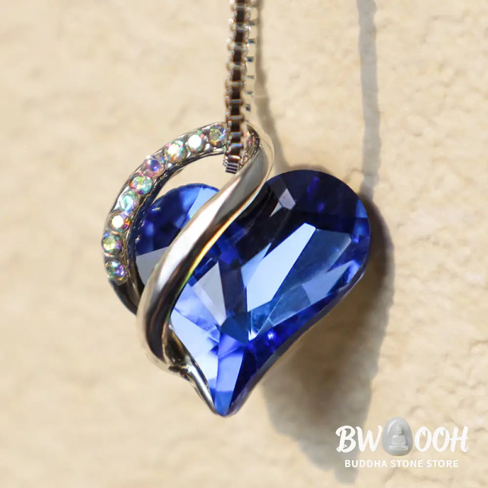 A BWOOOH Love Heart Birthstone Necklace pendant featuring a vibrant, wild-heart-shaped premium crystal, elegantly embraced by a silver-tone ribbon forming an infinity symbol, symbolizing triumph of love and eternal spiritual connection. - View 14