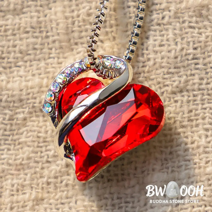 A BWOOOH Love Heart Birthstone Necklace pendant featuring a vibrant, wild-heart-shaped premium crystal, elegantly embraced by a silver-tone ribbon forming an infinity symbol, symbolizing triumph of love and eternal spiritual connection. - View 2