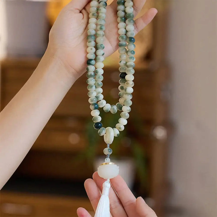 BWOOOH Natural 108 Bodhi Seed Mala Bracelet with carved lotus, luminous stone accents, and a wisdom tassel, displayed against a serene backdrop, ready for mindful practice.