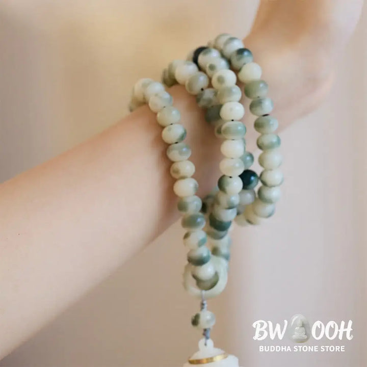 BWOOOH Natural 108 Bodhi Seed Mala Bracelet with carved lotus, luminous stone accents, and a wisdom tassel, displayed against a serene backdrop, ready for mindful practice. - View 9