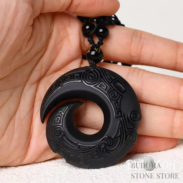BWOOOH Natural Black Obsidian and Ice Obsidian Peace Buckle Strength Necklace Pendant, showcasing a polished black obsidian stone adjacent to a translucent ice obsidian peace buckle on an adjustable cord. - View 4