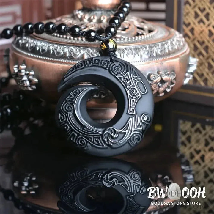 BWOOOH Natural Black Obsidian and Ice Obsidian Peace Buckle Strength Necklace Pendant, showcasing a polished black obsidian stone adjacent to a translucent ice obsidian peace buckle on an adjustable cord. - View 2