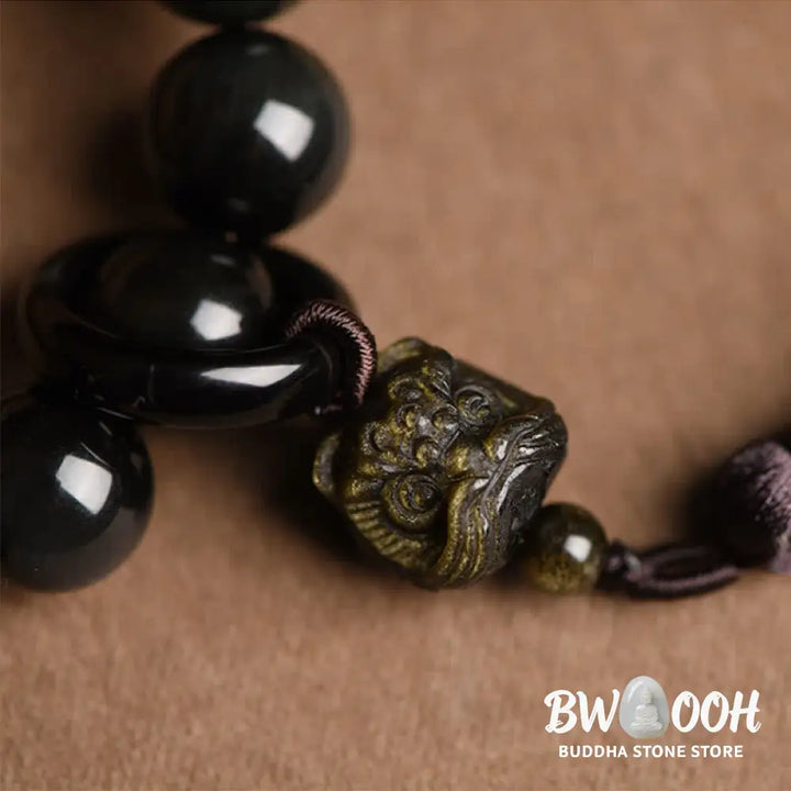 A BWOOOH Natural Black Obsidian Lion Wrist Mala with protection tassels, shown as a pocket mala and car decoration, embodying courage, wisdom, and spiritual enlightenment for energetic protection and positive Feng Shui. - View 5