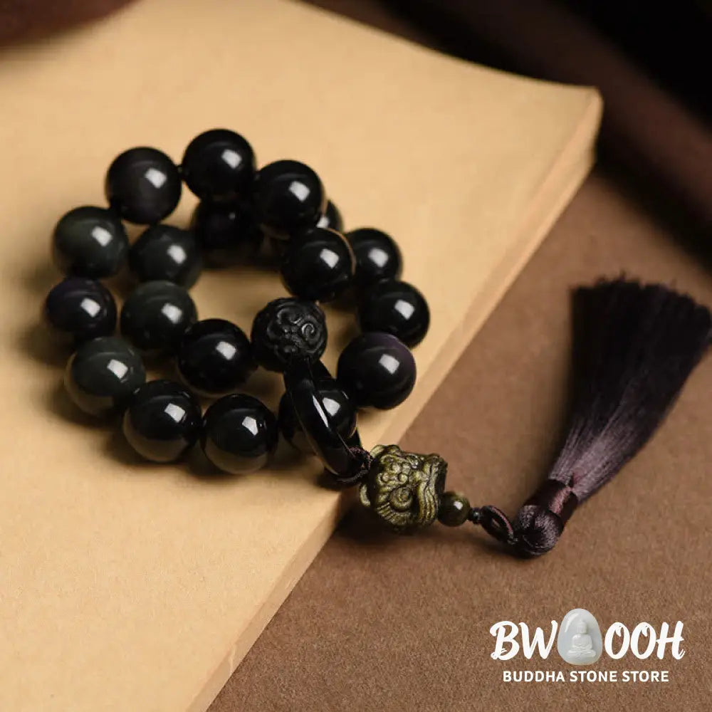 A BWOOOH Natural Black Obsidian Lion Wrist Mala with protection tassels, shown as a pocket mala and car decoration, embodying courage, wisdom, and spiritual enlightenment for energetic protection and positive Feng Shui. - View 4