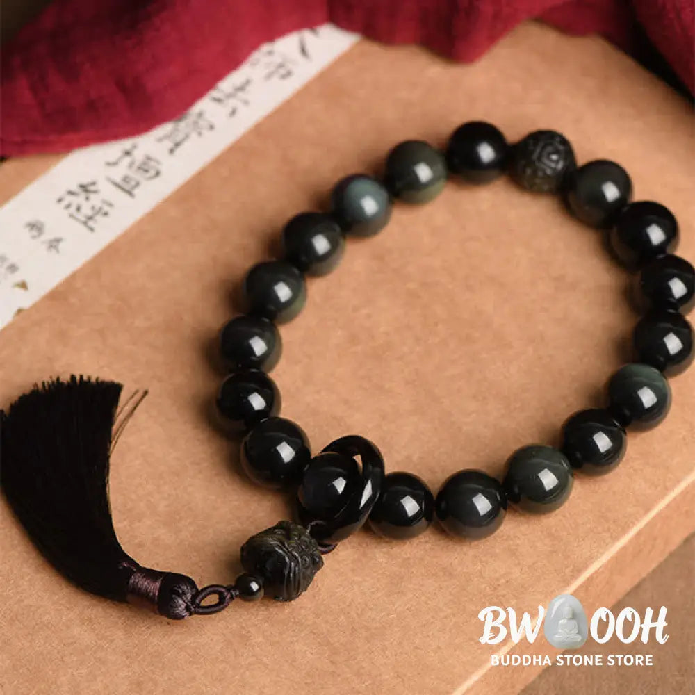 A BWOOOH Natural Black Obsidian Lion Wrist Mala with protection tassels, shown as a pocket mala and car decoration, embodying courage, wisdom, and spiritual enlightenment for energetic protection and positive Feng Shui. - View 3