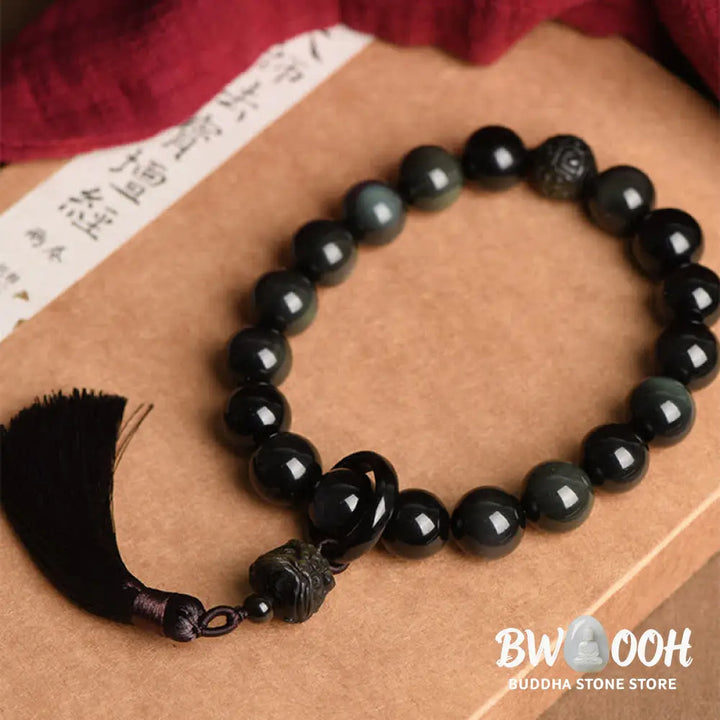A BWOOOH Natural Black Obsidian Lion Wrist Mala with protection tassels, shown as a pocket mala and car decoration, embodying courage, wisdom, and spiritual enlightenment for energetic protection and positive Feng Shui. - View 3