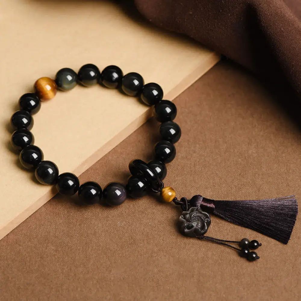 A BWOOOH Natural Black Obsidian Lion Wrist Mala with protection tassels, shown as a pocket mala and car decoration, embodying courage, wisdom, and spiritual enlightenment for energetic protection and positive Feng Shui. - View 8