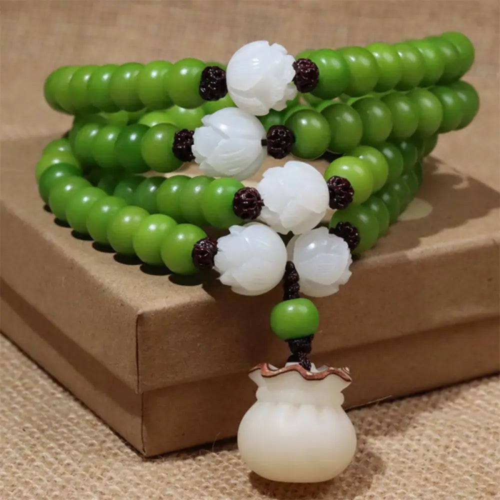 Close-up of BWOOOH Natural Bodhi Seed 108 Beads Mala Wisdom Bracelet, featuring dark-speckled 6mmx8mm seeds, symbolizing enlightenment and spiritual awakening, elegantly wrapped around a wrist for meditation.
