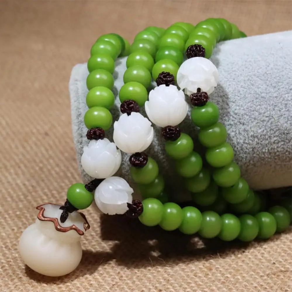 Close-up of BWOOOH Natural Bodhi Seed 108 Beads Mala Wisdom Bracelet, featuring dark-speckled 6mmx8mm seeds, symbolizing enlightenment and spiritual awakening, elegantly wrapped around a wrist for meditation. - View 2