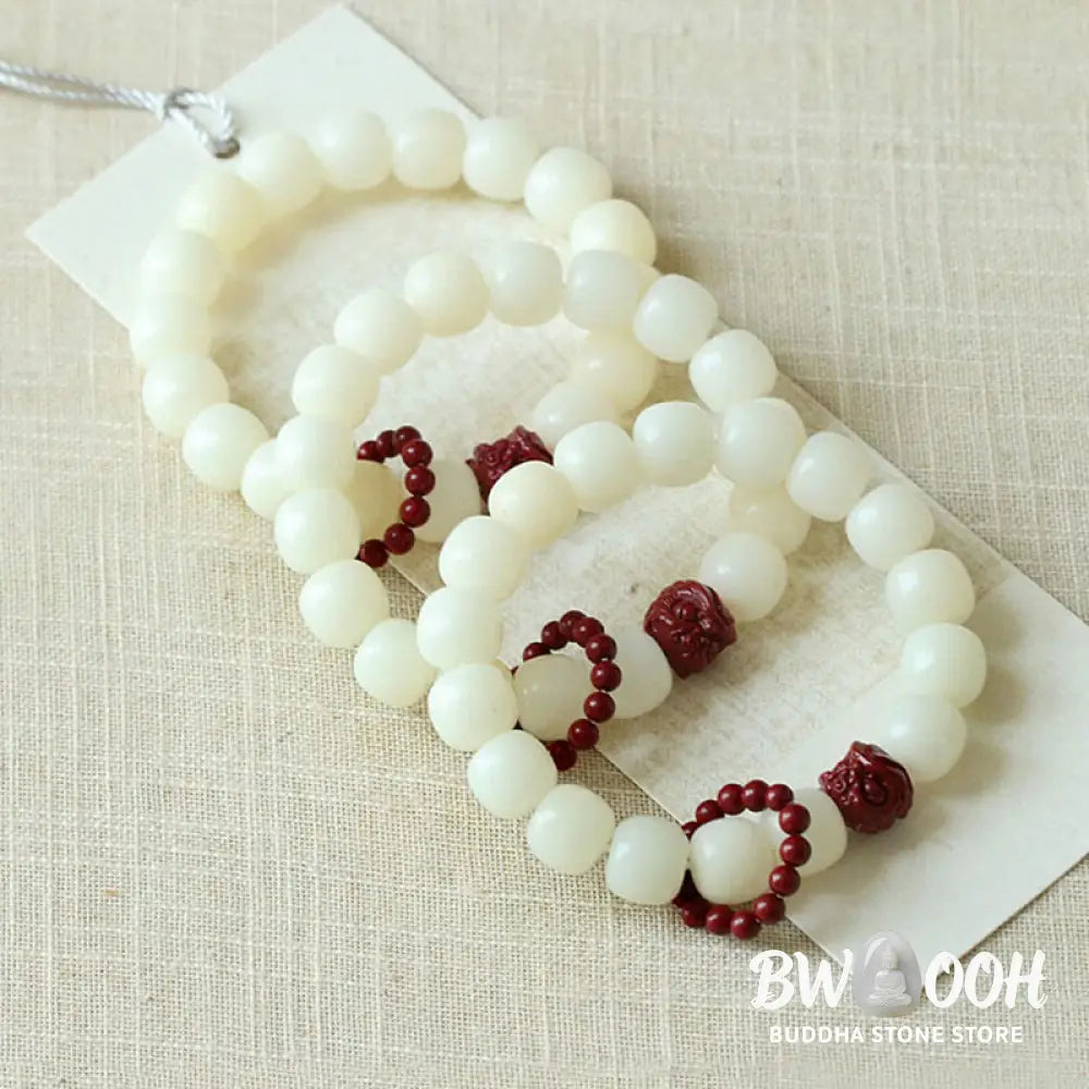 Close-up of BWOOOH Natural Bodhi Seed Wrist Mala with vibrant red Cinnabar beads and a detailed Dancing Lion charm on an elastic string, symbolizing wisdom, harmony, and protection during meditation practices. - View 6