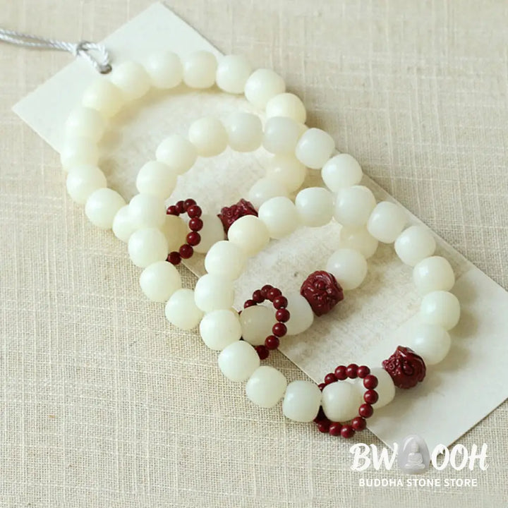Close-up of BWOOOH Natural Bodhi Seed Wrist Mala with vibrant red Cinnabar beads and a detailed Dancing Lion charm on an elastic string, symbolizing wisdom, harmony, and protection during meditation practices. - View 6