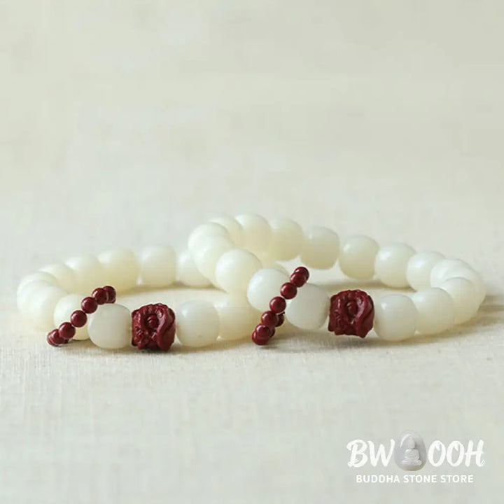 Close-up of BWOOOH Natural Bodhi Seed Wrist Mala with vibrant red Cinnabar beads and a detailed Dancing Lion charm on an elastic string, symbolizing wisdom, harmony, and protection during meditation practices. - View 5